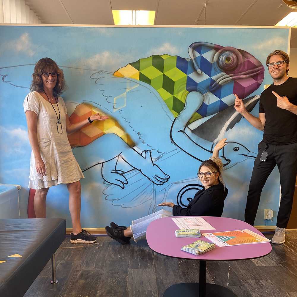 Personal står framför målning skapad under Bank Street Art Festival 2020, inne på kontoret i Gamleby