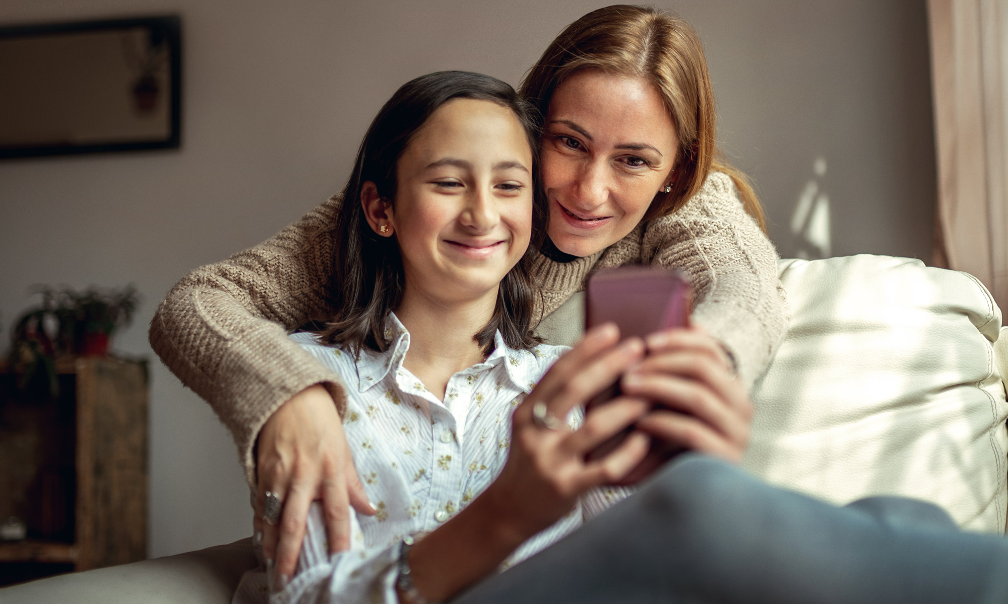 Woman and daughter looking at phone